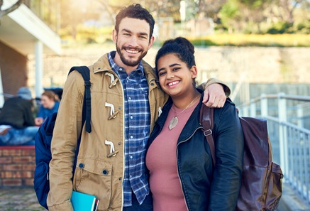 Two young people smiling together outdoors, showing connection and support